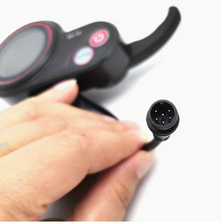 Hand holding a black electronic device with a small connector on a white background