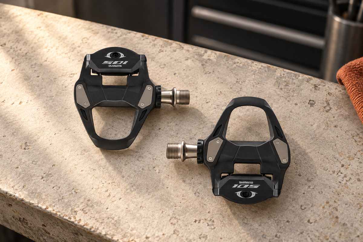 Shimano 105 SPD-SL road pedal pair on a workshop bench